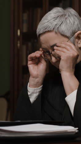 Senior Woman Lawyer Reviewing Documents in a Library Setting