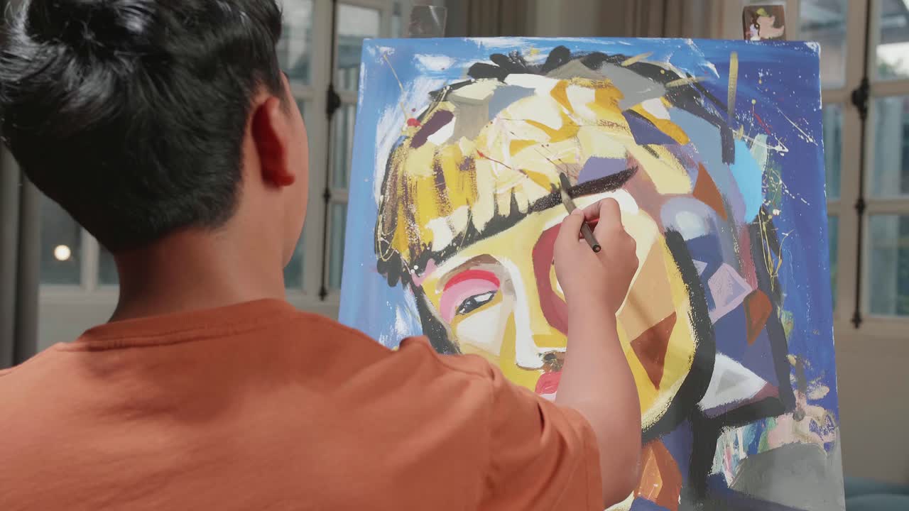 Hind View Of An Asian Artist Boy Holding Paintbrush Mixed Colour And Thinking Before Painting A Girl'S Hair On The Canvas