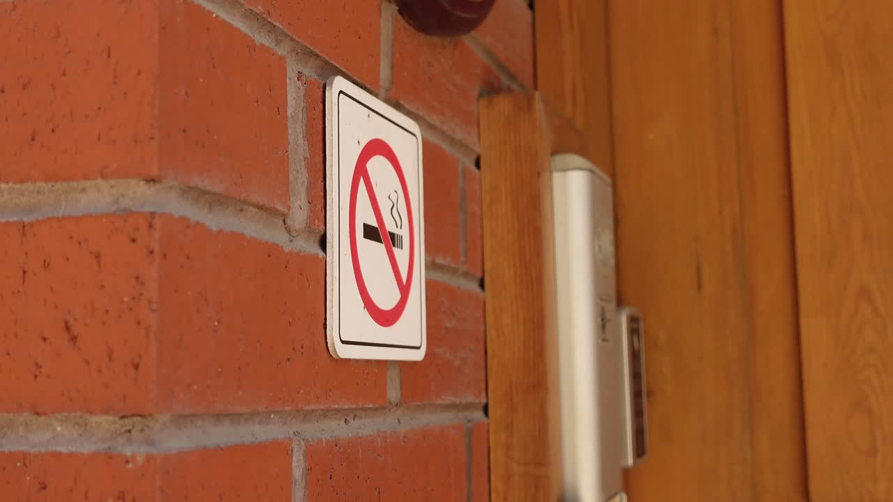 Skilt med 'Ingen rygning' på murstensvæg
