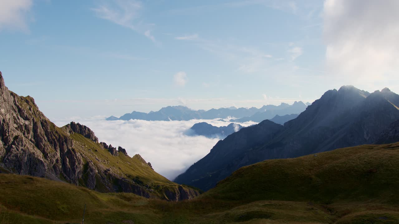 las nubes yacen en un valle con montañas alrededor
