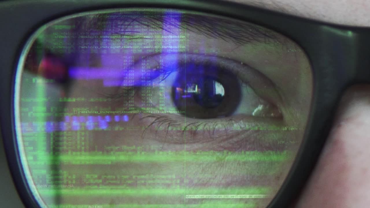 vista de cerca de un texto de codificación que se refleja en las gafas en color verde con reflejos azules en el estilo de matriz