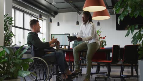 happy disabled and diverse business people discussing work during meeting at office