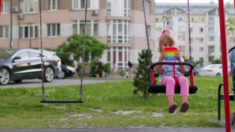 niño pequeño elegante niño jugar con pop de moda que burbuja juego de juguete sensorial suave en el columpio del patio de recreo