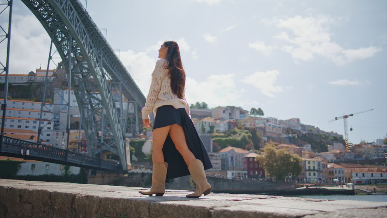 Romantic woman walking sunny promenade alone. Girl raising arms enjoying summer