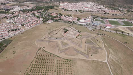 Aerial-overview-of-star-shaped-Forte-de-Santa-Luzia,-city-of-Elvas-in-background