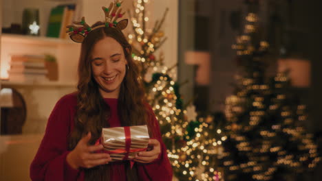 una mujer joven lanzando regalos en el aire en casa.