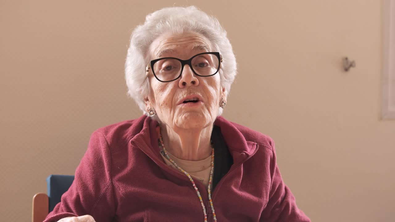 Elderly woman with short gray hair talking in nursing home