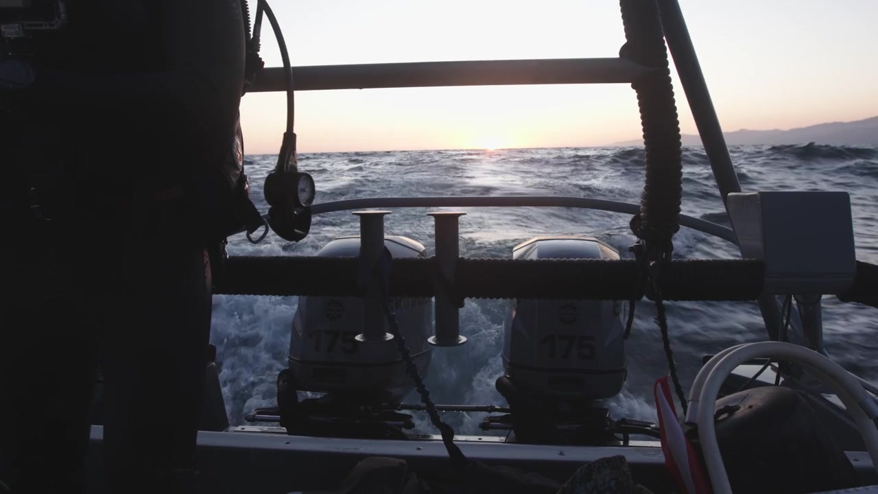 Subacqueo che torna da un'immersione nell'oceano mentre il sole tramonta.