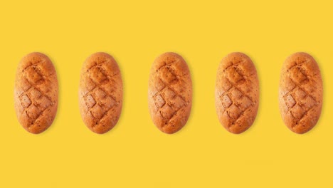 seamless looping animation of a whole diet loafs top view. funny movement of bread above a yellow background, copy space