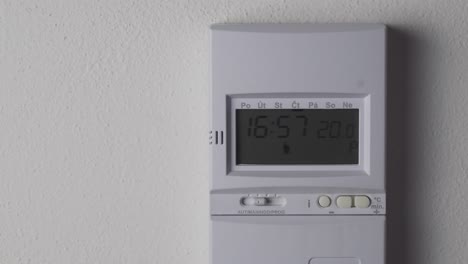 ajuste de la temperatura del termostato de calefacción más alta, pantalla digital y vista de primer plano con la mano