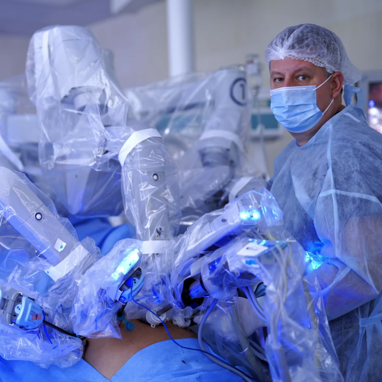 Medical operation involving robot. Professional doctor in mask near the medical robot in the operating room. Robotic surgery.