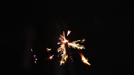 lit party sparkler sparkling on black background