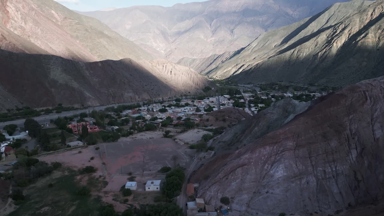 drone aéreo vuela sobre el valle de purmamarca, colinas de siete colores, pueblo, quebrada de humahuaca, ciudad del valle en un paisaje único de viaje sudamericano