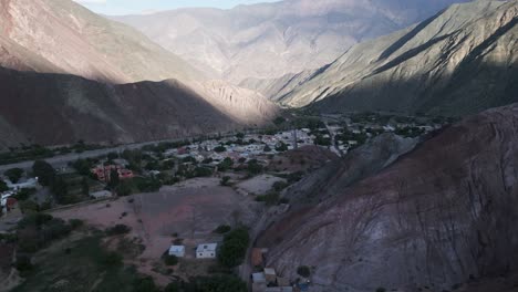 Aerial-Drone-Fly-Above-Valley-of-Purmamarca,-Hills-of-Seven-Colors,-Town,-Quebrada-De-Humahuaca,-Valley-City-at-Unique-South-American-Travel-Landscape