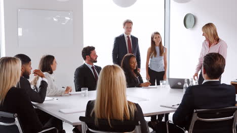 mujer de negocios madura dirigiéndose a una reunión de grupo en torno a la mesa en el día de evaluación de la contratación de graduados