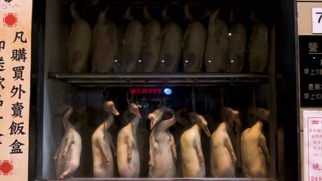 A-restaurant-displays-geese-for-consumption-hanging-from-a-fridge-in-Hong-Kong