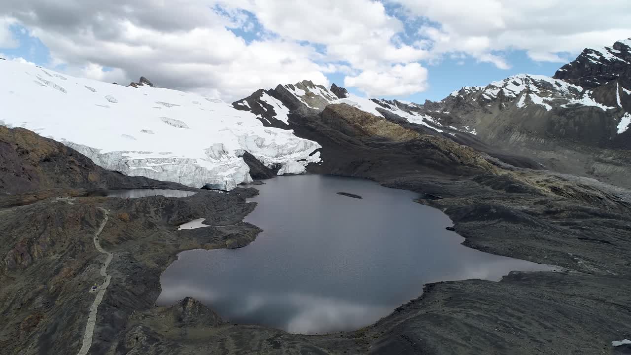 A pristine glacial lake reflects the towering Andes with snow-covered peaks