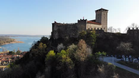 Un-Dron-Mavic-Air-Comienza-A-Moverse-En-Un-Punto-Más-Bajo-De-Rocca-Di-Angrya-Y-Se-Levanta-Suavemente-Hasta-El-Mismo-Nivel,-Revelando-El-Hermoso-Lago-Maggiore