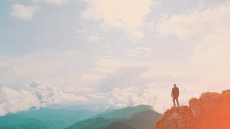 the young man stands on the mountain cliff