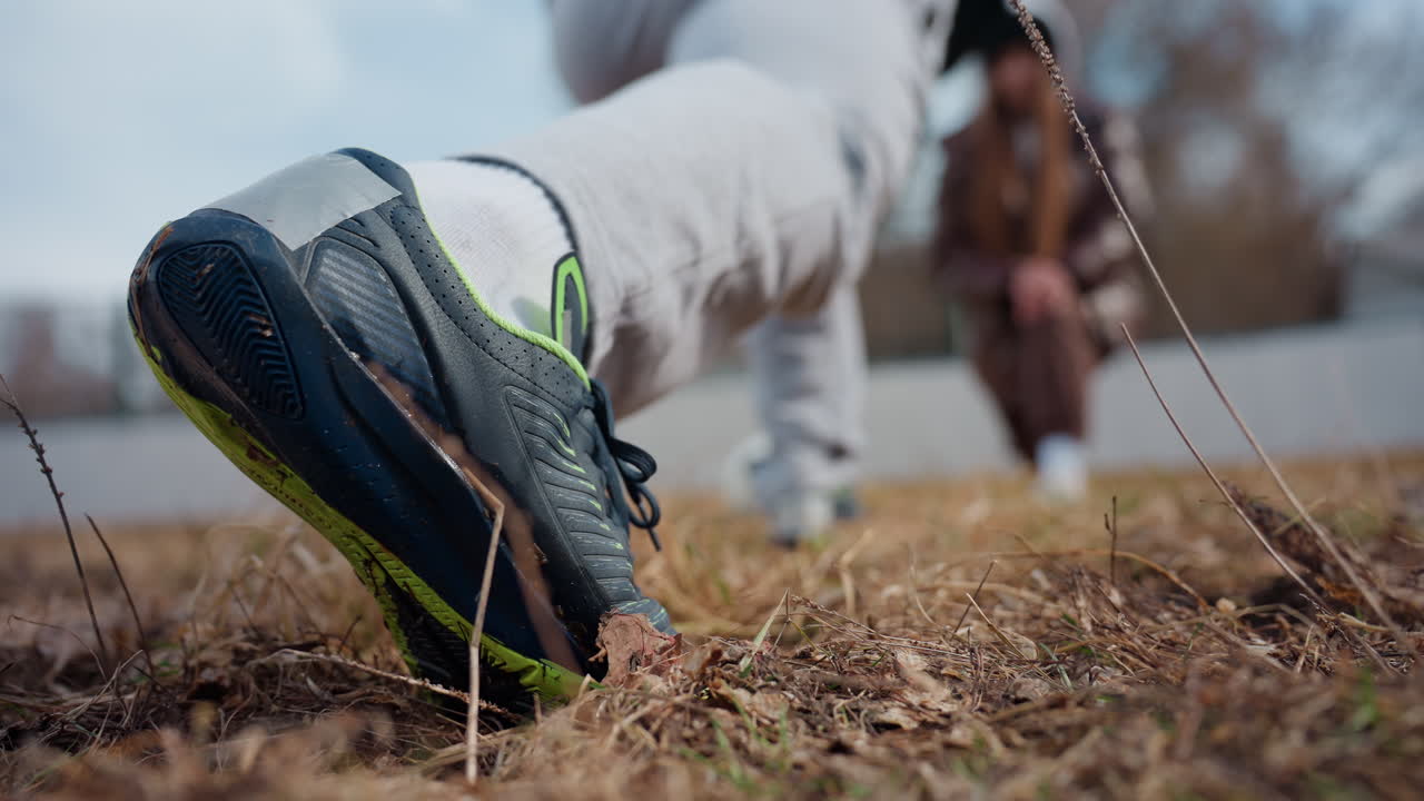활동적인 러너에 초점을 맞춘 도심 공원 풍경이에요. 운동화 밑창과 운동 자세를 클로즈업 이미지로 담았으며, 야외 공원 환경에서 움직임을 준비하는 운동화의 디테일한 장면을 촬영했어요.