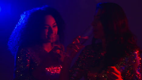 close up of two women in nightclub bar or disco dancing and drinking alcohol 5