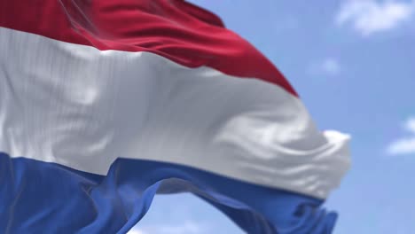 detail of the national flag of the netherlands waving in the wind on a clear day