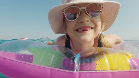 the father shoots his daughter on the video she has fun on an air mattress in the sea holiday with c