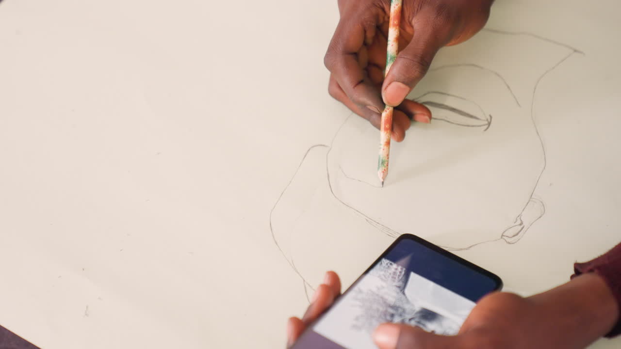 Black man sketching portrait from phone reference. Closeup hands drawing pencil outline on large paper, dotted construction lines, grayscale reference visible on phone screen, quiet studio atmosphere