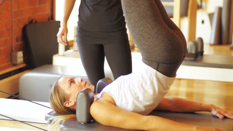 female trainer assisting woman with exercise