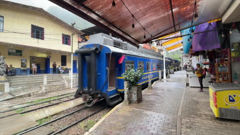 peru rail blue train arrives to machu picchu. tourist train moves on rails. peruvian transportation