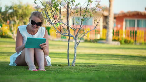 Beautiful-woman-sitting-barefoot-on-a-lawn