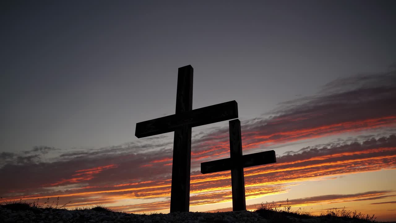 Croci in silhouette con un cielo drammatico al tramonto, riprese da un angolo basso