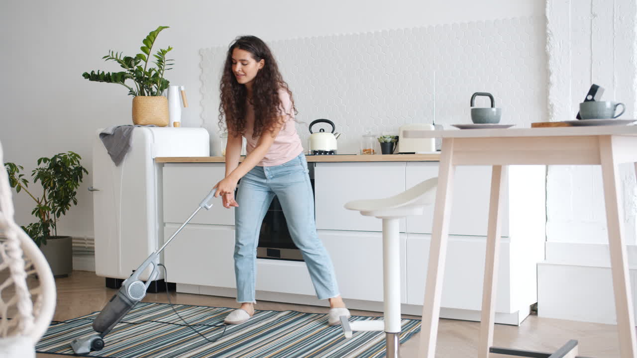 Woman cleaning and dancing in the kitchen