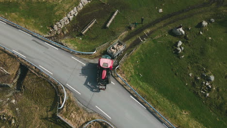 tractor transporting sheep in a trailer to new pasture, overhead drone view