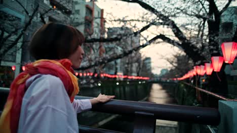 woman taking photos of cherry blossoms in japan