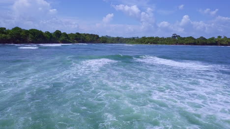 aerial-shot-of-sea-waves-looking-towards-land-on-sunny-day