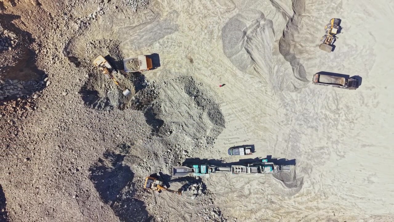 Granite quarry site with machinery and workers engaged in stone extraction and transport operations
