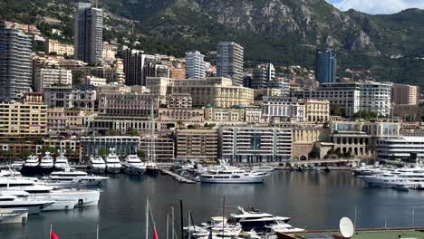 modern solar panels on roof of building at marina port of monaco town. sunny day in french city state. yachts and sailing boats parking in front of hilly housing area. towers and downtown in summer.