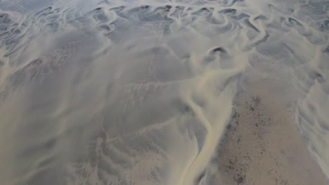 tomada aérea de arriba hacia abajo del delta del río glacial y el patrón abstracto en islandia