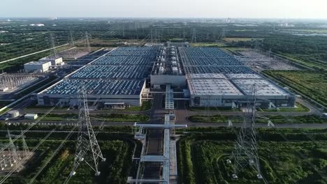 aerial view of a vast industrial area featuring a large facility surrounded by multiple power lines and electricity infrastructure.