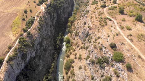 Toma-Aérea-Del-Cañón-Aggitis-Siguiendo-El-Río-Y-La-Acera,-Hito-Natural-De-Grecia