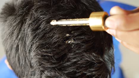 aplicación de aceite para el cabello en el cuero cabelludo