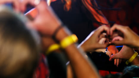 Hands-of-audience-forming-heart-shape-during-stage-show-4k