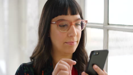 Trendige-Frau-Mit-Brille,-Die-Ihr-Telefon-Benutzt