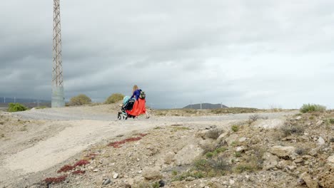 Junge-Abenteuerlustige-Mutter-Kämpft-Mit-Kinderwagen-In-Der-Rauen-Landschaft-Teneriffas