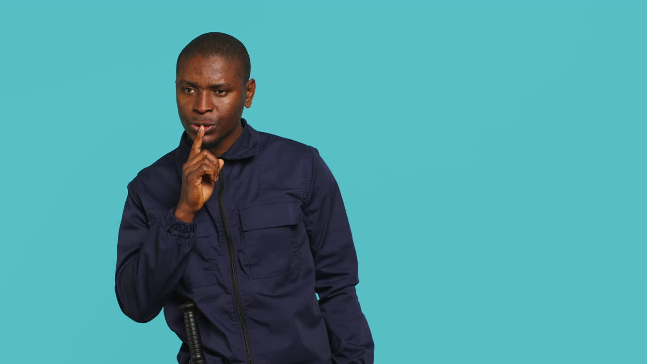Portrait of security guard doing shush sign gesturing with finger