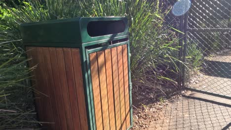 person throwing bottle into trash bin