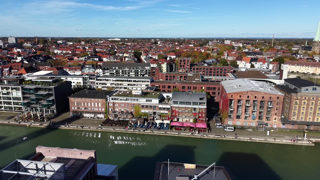 Luxury waterside promenade riverwalk in German town with noble apartments on sunny day. Aerial lateral wide shot. Historic town of Münster, Germany