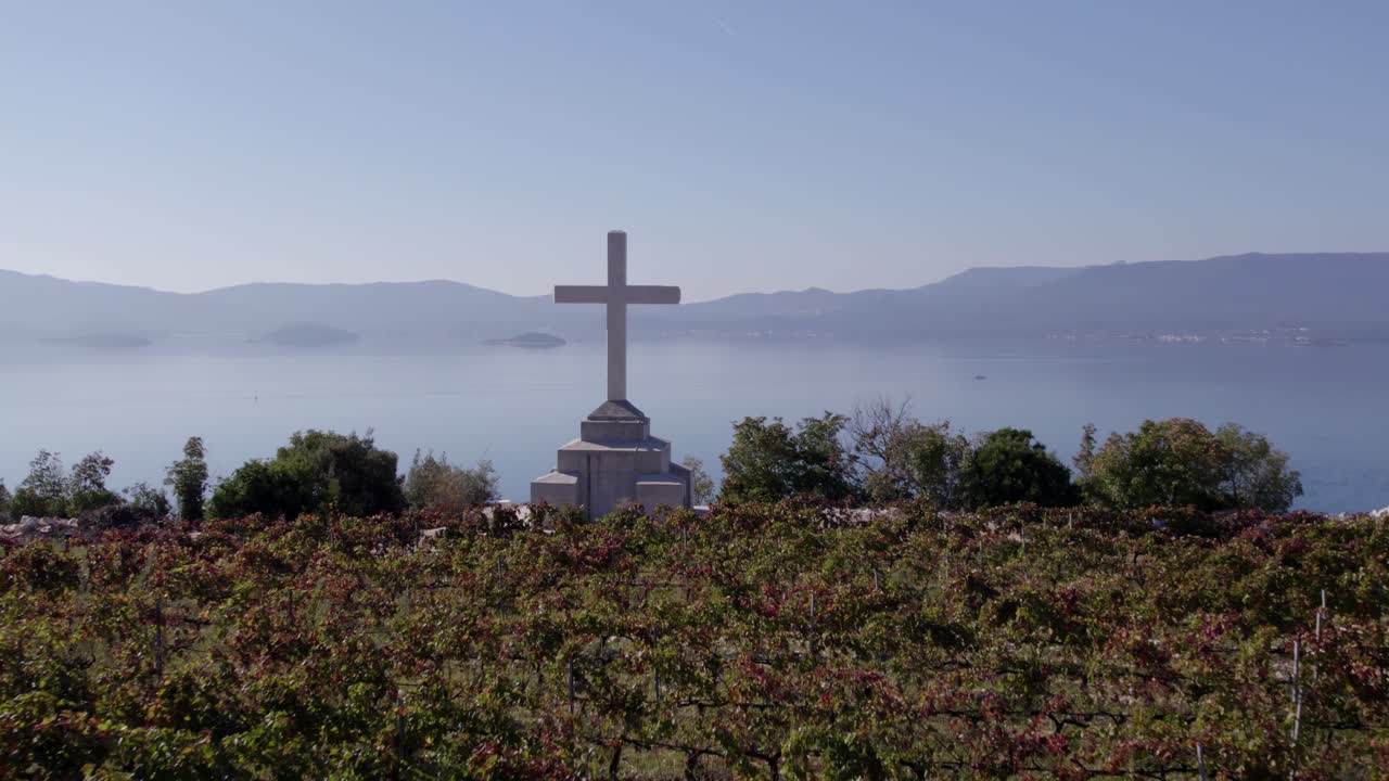 Ripresa dall'alto di vigneti e una croce eretta su pendii scoscesi, Slivno.