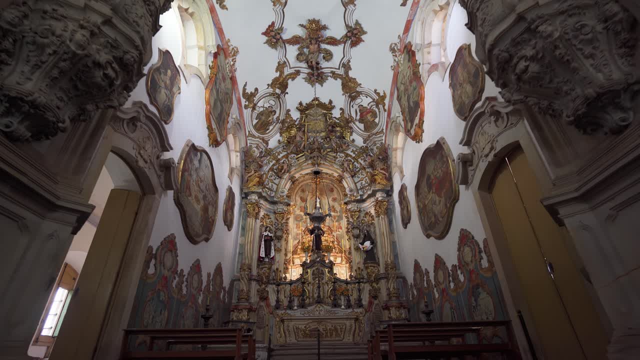 Wide low-angle push-in shot inside the Church of Saint Francis of Assisi, highlighting the intricate altar details in Ouro Preto, Minas Gerais, Brazil (Ouro Preto, Minas Gerais, Brasil)